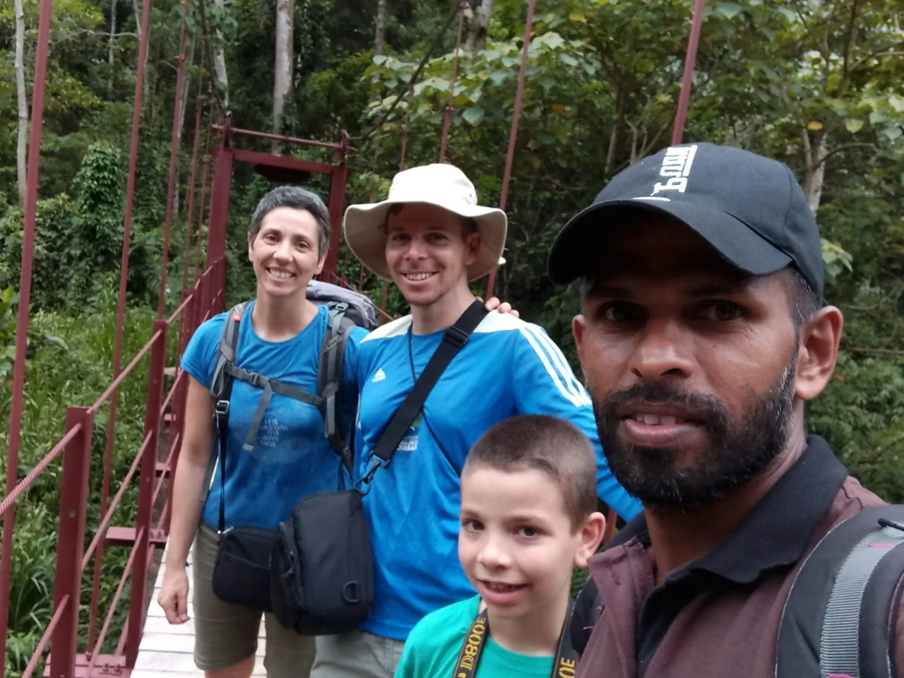 A guide with a family on a rainforest bridge