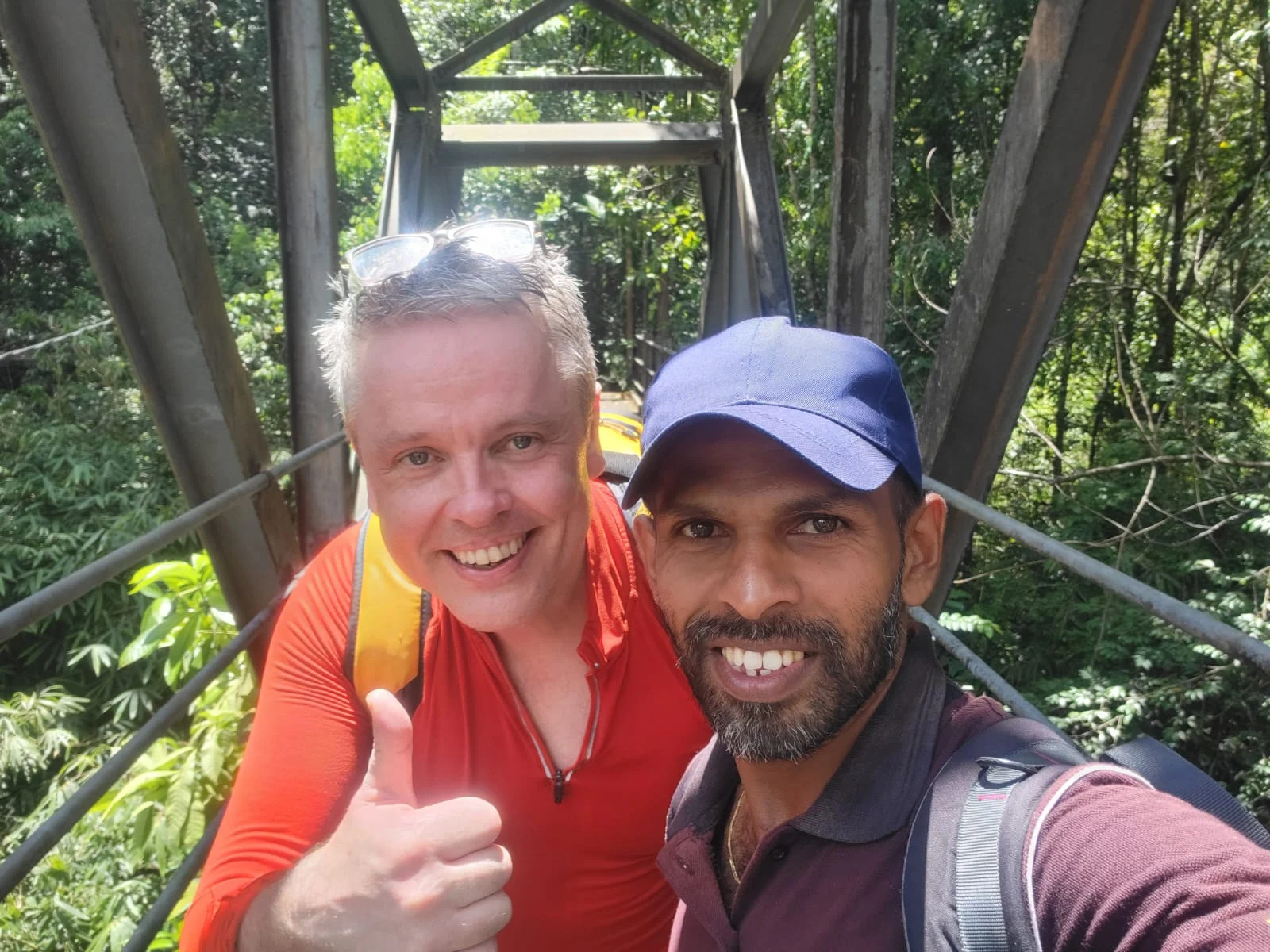 A local guide and guest on a rainforest bridge